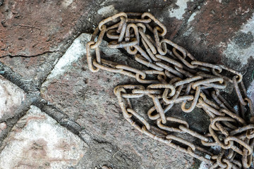 Rusty chain on the brickwork. The symbol of slave labor
