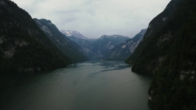Aerial dark cinematic shot of the Konigsee lake in Bavarian Alps, Germany before the storm