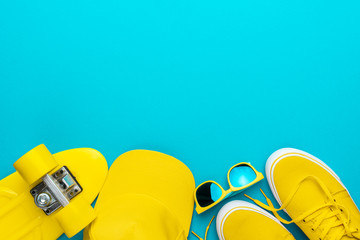 Top view of yellow modern teenage accessories. Flat lay image of yellow baseball cap, sunglasses,...