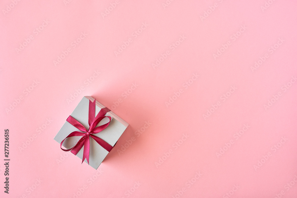 Wall mural gift box with ribbon and bow on color background and space for text. top view