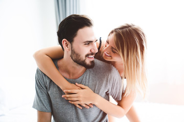 Fototapeta premium Cute couple relaxing on bed and hugging, love and relationships concept