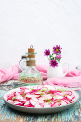 Fresh salad of pieces of radish and dill on a plate on a wooden table. Ready snack for a diet