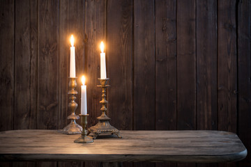 burning candle on old wooden background