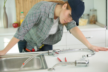 a woman fixing kitchen sink