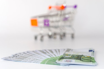 Euro banknotes with shopping basket background - 277238539