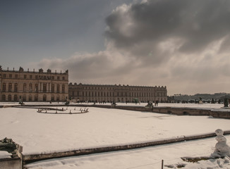 Fototapeta na wymiar garden sculptures and pond in front of the royal residence at Versailles near Paris in France in winter scenery