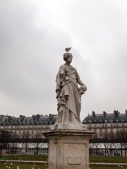 Fototapeta na wymiar a bird on the head of one of the figures in a park in Paris,