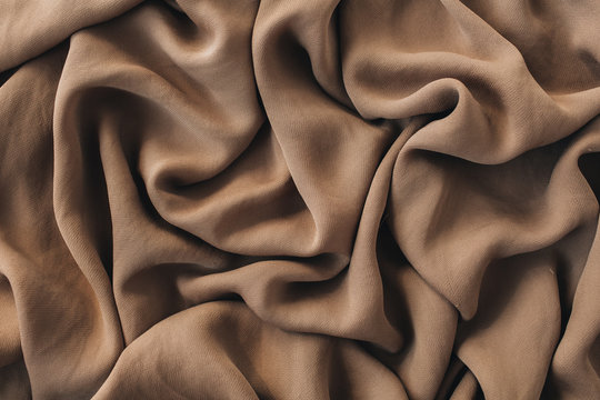 Brown silk crumpled linen texture pattern. Closeup textile background.