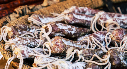 Dry meat salami or sausage on wicker basket