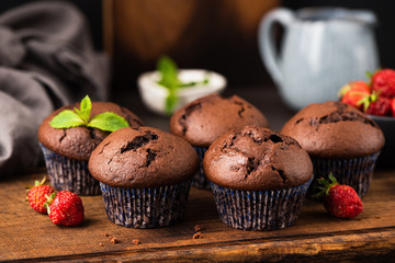 Homemade chocolate muffins on wooden cutting board, horizontal orientation