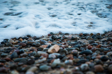 Rocks on the beach with wave closeup