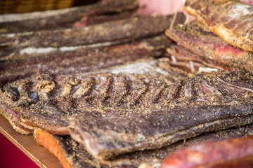 Dry meat with salt and pepper on medieval market closeup