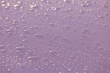 pink drops from the sunset on a white car