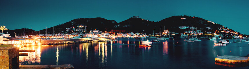 Night scene panorama view of the idyllic harbor with boat and restaurants and the mountain in the background.Port d' Andratx, Port Andratx, Mallorca Spain Balearics 