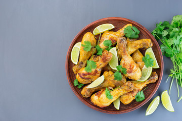 Indian chicken tandoori, marinated in greek yogurt and spices, served with lime wedges and cilantro, horizontal, top view, copy space