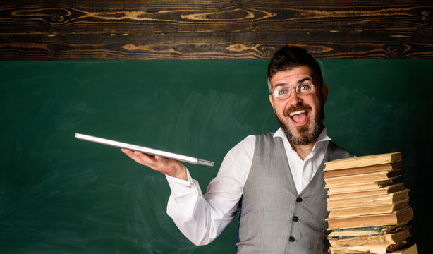 Happy male teacher holds book and laptop. Modern technologies benefit. Paper book against laptop. Online education and learning. Take advantage technologies development. Education and technology.