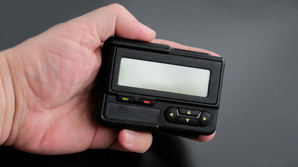 Old black pager in hand