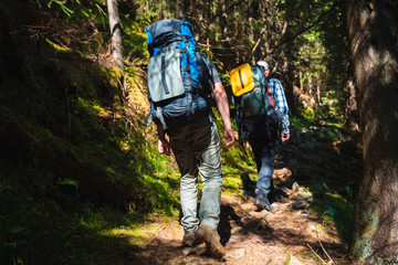 Two friends travel in the mountains with backpacks