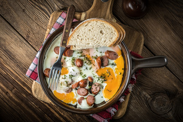 Tasty cooked egg with chopped sausages.