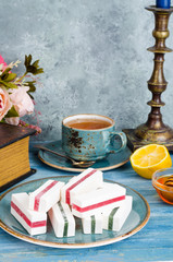 Composition on table with marshmallows, cup of tea.