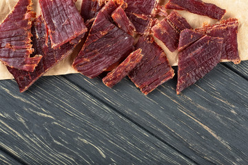 Beef jerky on a wooden board, close-up.