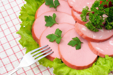 Slices of sausage, salad and parsley on the plate