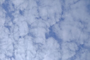 White cotton candy clouds against blue sky for background backdrop 