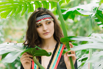 The girl from Jordan on the background of plants and palm leaves. Jordanian girl in the national costume of the Arab state