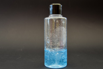 A bottle of household chemicals cosmetics on a black background neck of a bottle close up macro...