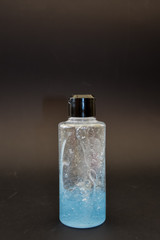 A bottle of household chemicals cosmetics on a black background neck of a bottle close up macro...