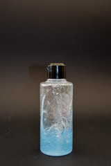 A bottle of household chemicals cosmetics on a black background neck of a bottle close up macro pattern