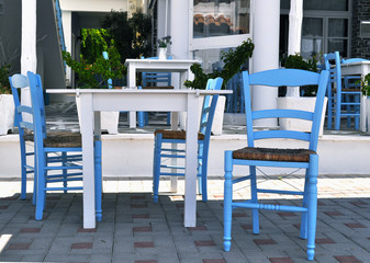 Blue table and chairs on the street in Greece