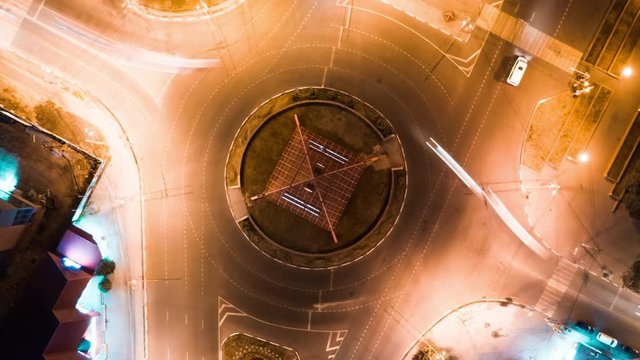 Hyperlapse timelapse of night city traffic on stop street intersection circle roundabout in megalopolis