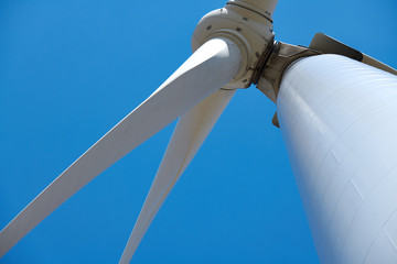Electricity wind generator on bright cloudy sky background - wind energy and technology concept
