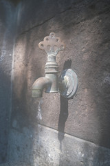An old tap in a stone wall.