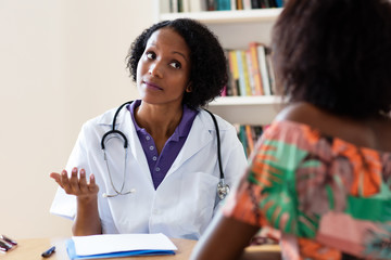African american female gynecologist talking to patient