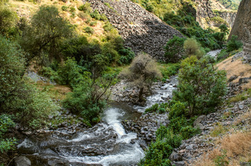  Destroying everything in its path, the Azat river, shallow in summer, carrying stones from the mountains, flows through the Garni gorge in Armenia