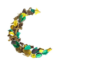 Creative flower composition in form of crescent of dry flowers and petals, green leaves. Top view, flat lay. 