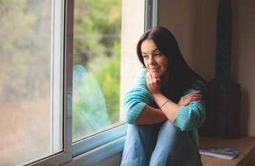 woman sitting on the window sill