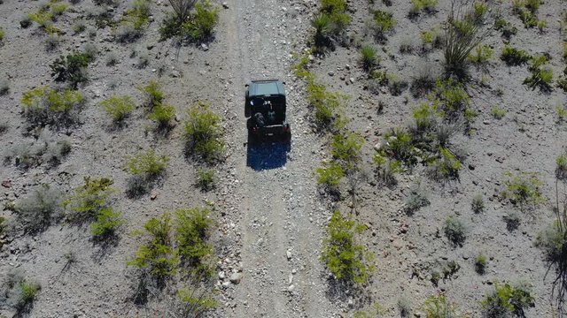 Aerial Follow ATV Up a Mountain Side. aerial view follows a side-by-side terrain vehicle up a mountain trail