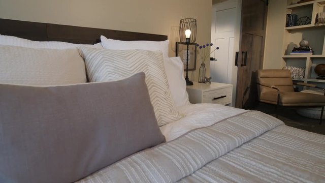 Move From Bed Detail to Closet Space. view moves right from a bed pillow detail shot to reveal bedroom and closet area