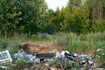 mountains of garbage lie along the road at the edge of the forest. Ecological catastrophy