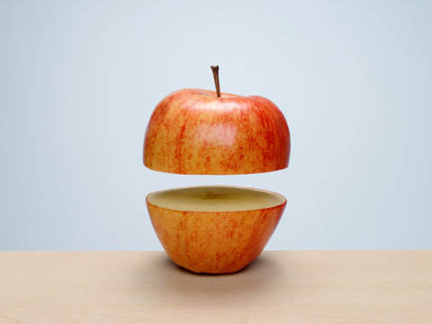 Ripe red apple cut in half with top floating above bottom