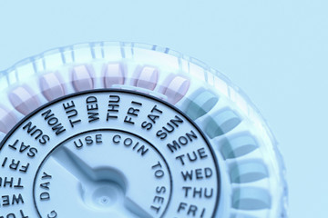 Closeup of birth control pill dispenser showing days of the week