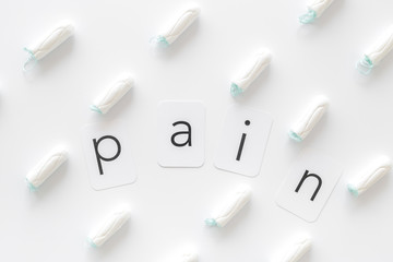 Woman hygiene and menstrual period concept with sanitary pads and pain word on white background top...