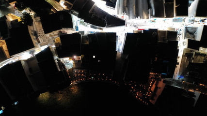 Aerial drone night shot of iconic and picturesque illuminated Little Venice in main town of Mykonos...