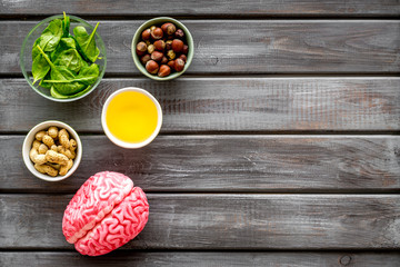 Proper nutrition for brain with nuts, spinage and oil stethoscope on wooden background top view copy space