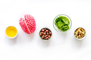 Proper nutrition for brain with nuts, spinage and oil stethoscope on white background top view