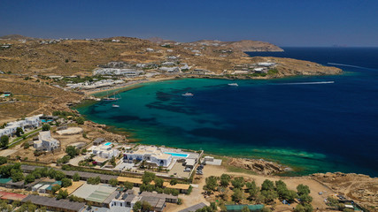 Aerial drone bird's eye view from famous beach of Paraga and Agia Anna featuring iconic Skorpios club and Santa Anna with largest pool in Europe, Mykonos island, Cyclades, Greece