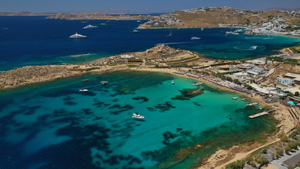 Fototapeta na wymiar Aerial drone bird's eye view from famous beach of Paraga and Agia Anna featuring iconic Skorpios club and Santa Anna with largest pool in Europe, Mykonos island, Cyclades, Greece